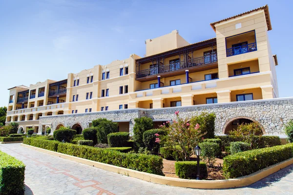 The building with the flowerbed on the background of blue sky — Stock Photo, Image