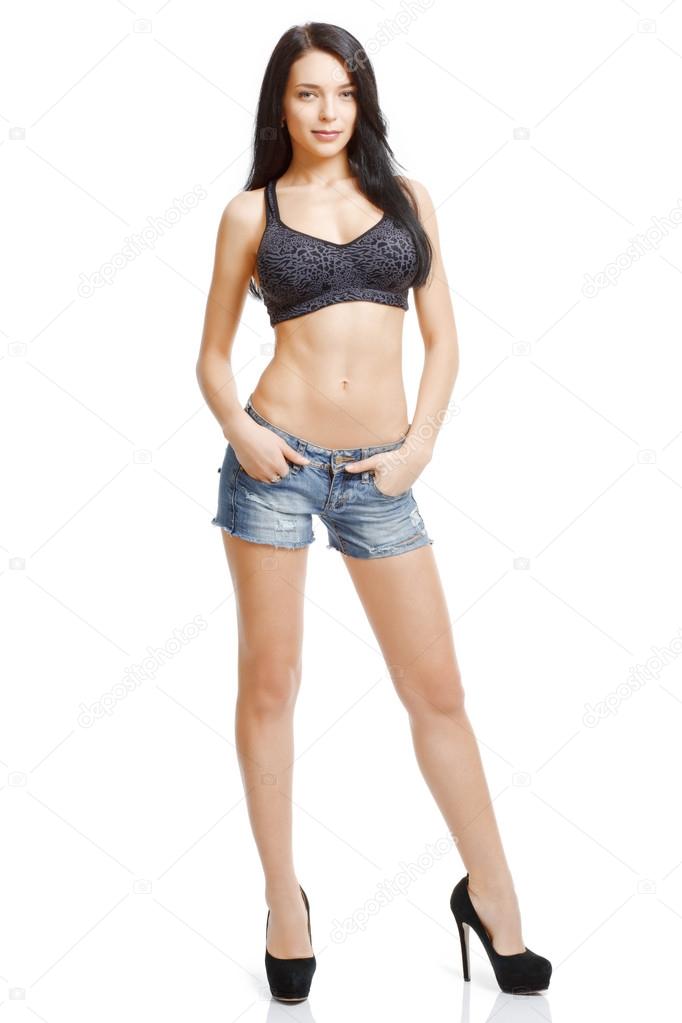 Athletic, slim girl in denim shorts and a sports bodice isolated