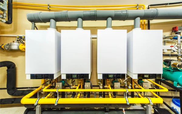 A row of four powerful domestic gas boilers — Stock Photo, Image