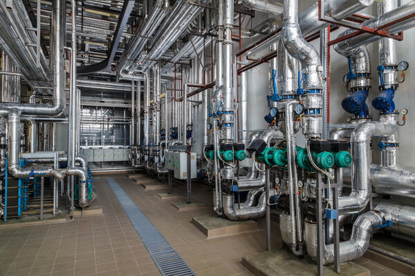 industrial boiler interior with lots of pipes, pumps and valves