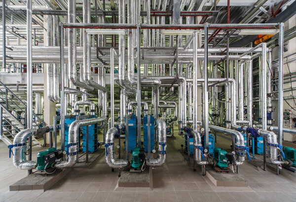 industrial boiler interior with lots of pipes, pumps and valves