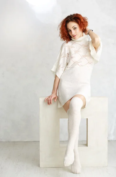 Kızıl saçlı kıvırcık kız beyaz örgü kazak ve çorap dikkat — Stok fotoğraf