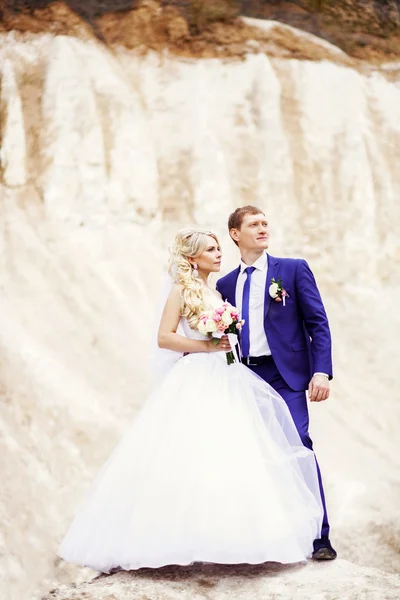 Portrait of the bride and groom on the background of white cliff — Stock Photo, Image