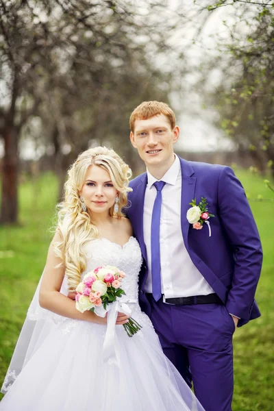 Wedding portrait of the bride and groom in the spring garden — Stock Photo, Image