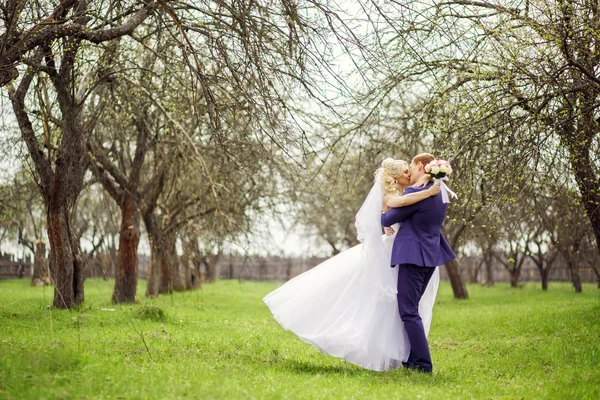 Wedding portrait of the bride and groom in the spring garden — Stock Photo, Image