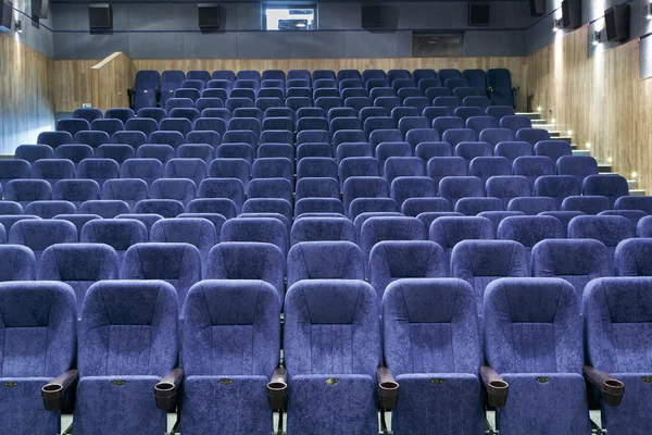 Interior room with lots of blue theater chairs