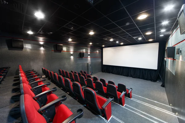 Interior de um pequeno teatro com cadeiras vermelhas e tela — Fotografia de Stock