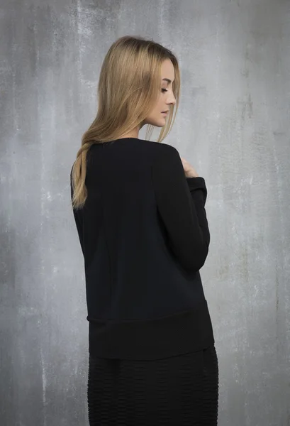 Portrait of fashionable girl in a black dress, standing on a gra — Stock Photo, Image