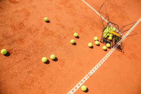 Mahkeme dağınık tenis topları sepet — Stok fotoğraf