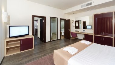 Otel odasında bir büyük yatak, Tv ve bazı Odalar