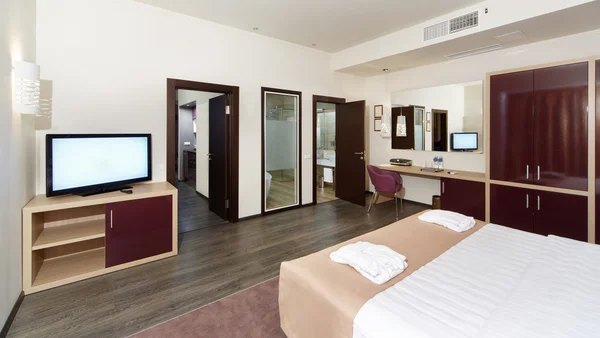 Otel odasında bir büyük yatak, Tv ve bazı Odalar