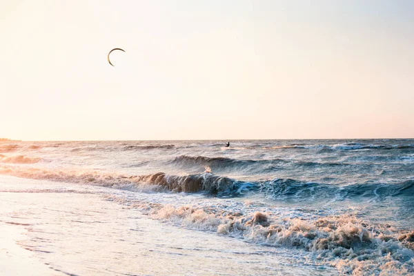 Kitesurfing vid solnedgången: manliga surfare silhuett till havs — Stockfoto
