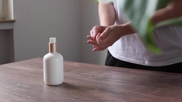 Middle aged caucasian woman appying hand cream, no face visible, home interior setting — Video Stock