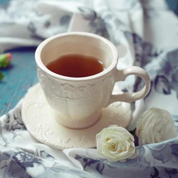 Cup of tea set with a beautiful tea towel and roses on a wooden — Stock Photo, Image