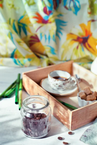 Burk av kaffebönor med en kopp kaffe och tillbehör — Stockfoto