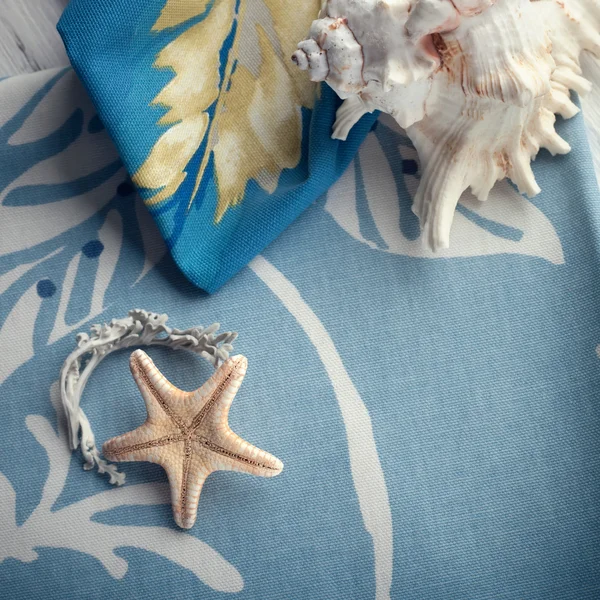 Composition with sea shells and a starfish set on cotton towels — Stock Photo, Image