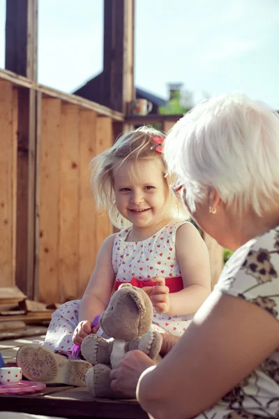 Feliz niña y su abuela jugando al té — Foto de Stock