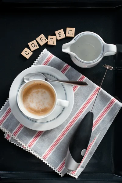 Cup of cappuccino set with milk blender and letters "coffee" — Stock Photo, Image