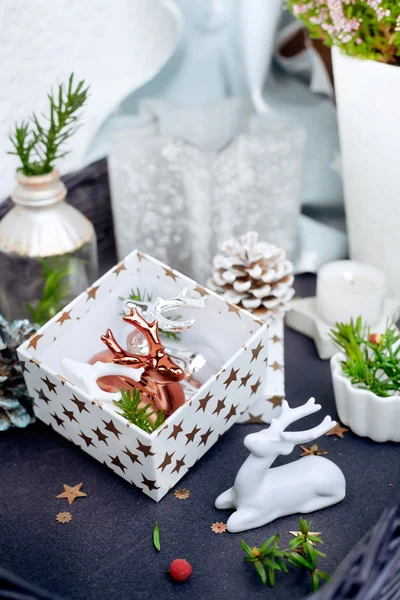 Decoración de Navidad - renos de cerámica y cajas de regalo en la mesa de café — Foto de Stock