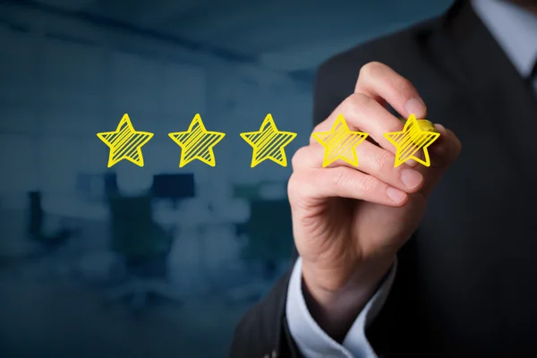 Businessman drawing five yellow stars — Stock Photo, Image