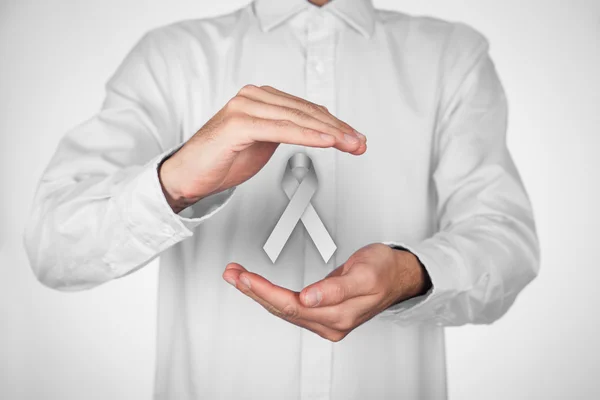 Gray ribbon in hands — Stock Photo, Image