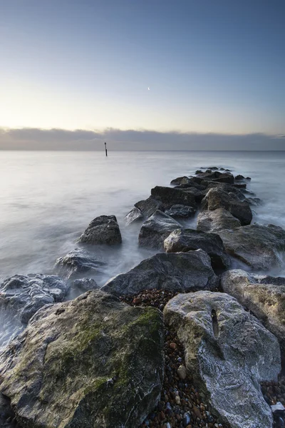 Atemberaubende Sonnenaufgangslandschaft über Felsen im Meer — Stockfoto