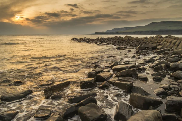 Beautiful sunset landscape image of rocky coastline in Kimmeridg — Stock Photo, Image