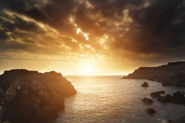 Güzel gün batımı peyzaj üzerinde denize bakan kayalık cove