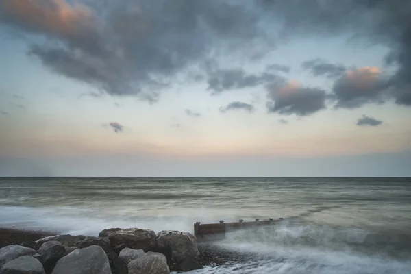 Beautiful long exposure sunset landscape image of pier at sea in — Stock Photo, Image