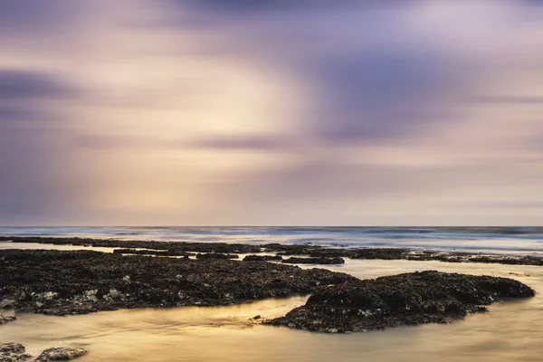 Atemberaubende felsige Strand Sonnenuntergang Landschaft lange Belichtung — Stockfoto