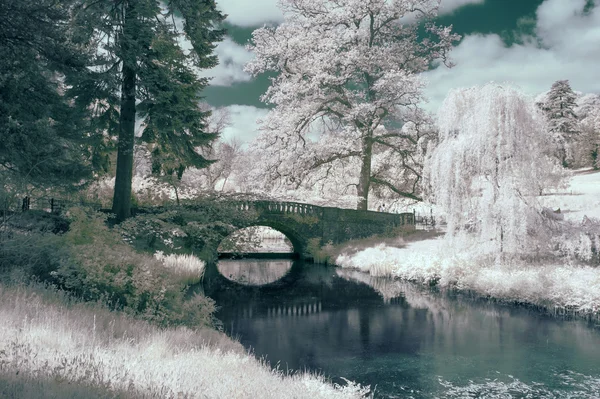 Prachtige infrarood landschap foto van de oude brug over de rivier in co — Stockfoto