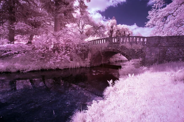 Prachtige infrarood landschap foto van de oude brug over de rivier in co — Stockfoto