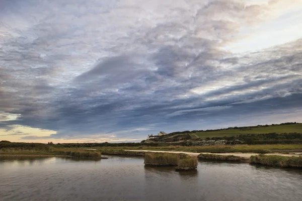 Landscape image of tidal pool at coast during evening with drama — Stock Photo, Image