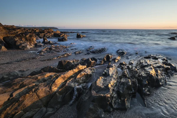 Belle image de paysage de coucher de soleil vibrant de mer calme contre roc — Photo