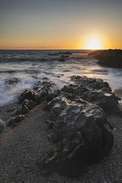 Belle image de paysage de coucher de soleil vibrant de mer calme contre roc — Photo