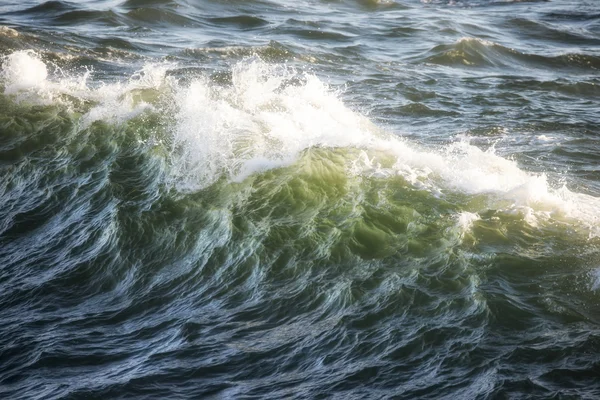 Hermosa cresta de ola oceánica estrellándose al atardecer con retroiluminación — Foto de Stock