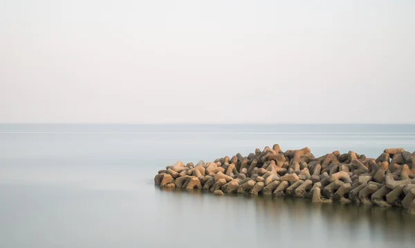 美丽的岩石露头进入平静的海面的平静景色 — 图库照片