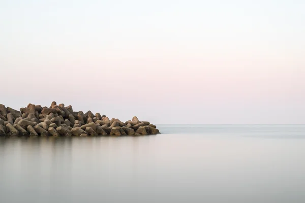 Beautiful calm landscape of rocky outcrop into calm sea — Stock Photo, Image