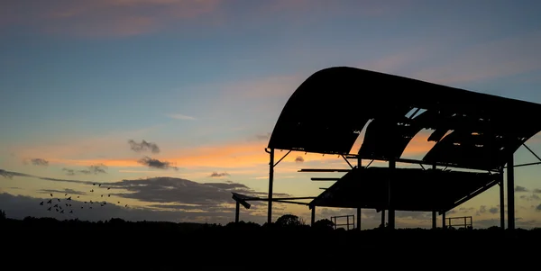 Brachliegende Scheunensilhouette vor wunderschönem, lebendigen Sonnenuntergang — Stockfoto