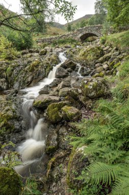 İngiliz Lake District 'teki Ashness Köprüsü' nün güzel uzun pozlu manzarası yaz öğleden sonra karamsar havayla birlikte.