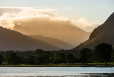 Loweswater boyunca Lkae Bölgesi 'ndeki Grasmoor ve Mellbreak dağlarındaki muhteşem ışığa bakan güzel bir gündoğumu manzarası.