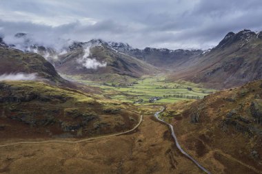 Langdale mızraklarının ve kışın alçak seviye bulutlar ve sisli vadisinin destansı uçan hava aracı görüntüsü.