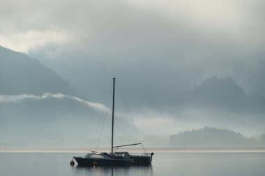 Bir kış sabahı Derwentwater Gölü 'ndeki yelkenli teknesinin güzel sakin görüntüsü.