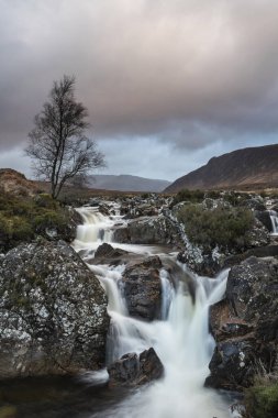 Bir kış sabahı İskoç dağlarında Buachaille Etive Mor şelalesinin çarpıcı manzara görüntüsü.