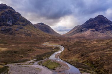 Uçan dron dramatik manzara görüntüsü Buachaille Etive Mor ve İskoçya 'da bir kış günü dağları ve vadileri çevreleyen