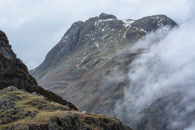 Baş döndürücü kış manzarası. Yan Pike 'tan Langdale mızraklarına doğru. Dağın tepesinde alçak seviye bulutlar ve karamsar sis var.