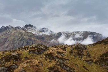 Langdale mızraklarının ve kışın alçak seviye bulutlar ve sisli vadisinin destansı uçan hava aracı görüntüsü.