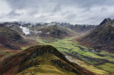 Langdale mızraklarının ve kışın alçak seviye bulutlar ve sisli vadisinin destansı uçan hava aracı görüntüsü.