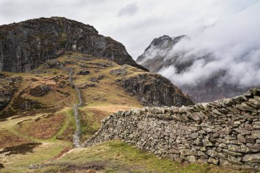 Baş döndürücü kış manzarası. Yan Pike 'tan Langdale mızraklarına doğru. Dağın tepesinde alçak seviye bulutlar ve karamsar sis var.