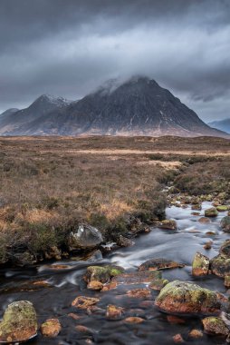 Buachaille Etive Mor ve River Etive 'in destansı dramatik manzarası İskoçya' da bir kış sabahı karamsar gökyüzü ve aydınlatma ile